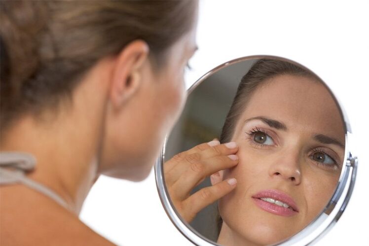 girl looking in the mirror before rejuvenating the skin